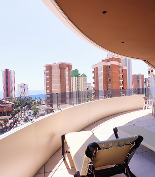 Balc&oacute;n con vista a edificios y al mar en el horizonte.