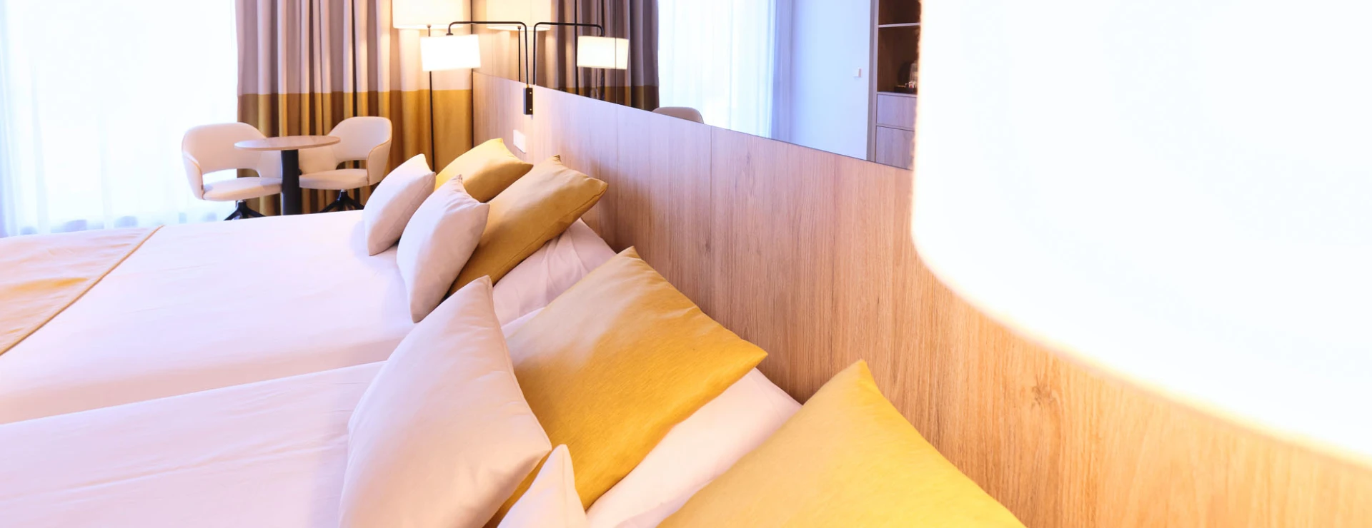 Habitaci&oacute;n moderna con cama doble y tonos c&aacute;lidos.