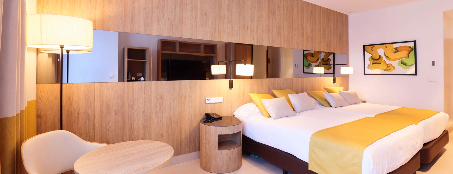 Habitaci&oacute;n de hotel moderna con cama doble y decoraci&oacute;n minimalista.
