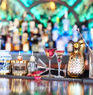 Barra con copas de c&oacute;ctel, licoreras y decoraci&oacute;n elegante.