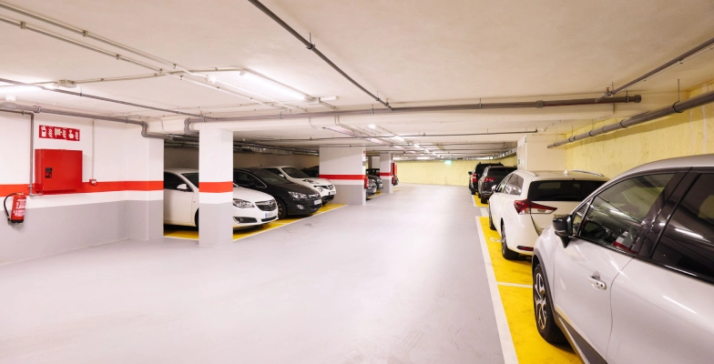 Estacionamiento subterr&aacute;neo con varios autos estacionados.