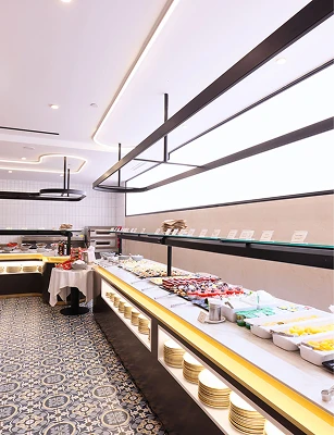 Buffet iluminado con una variedad de alimentos y platos listos para servir.