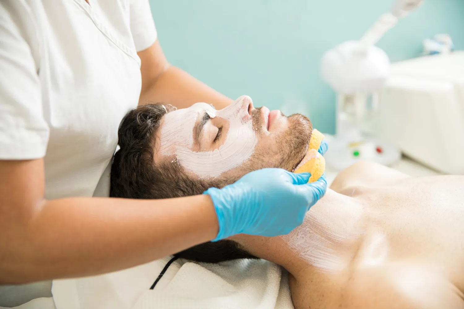 Hombre recibiendo un tratamiento facial en un spa.