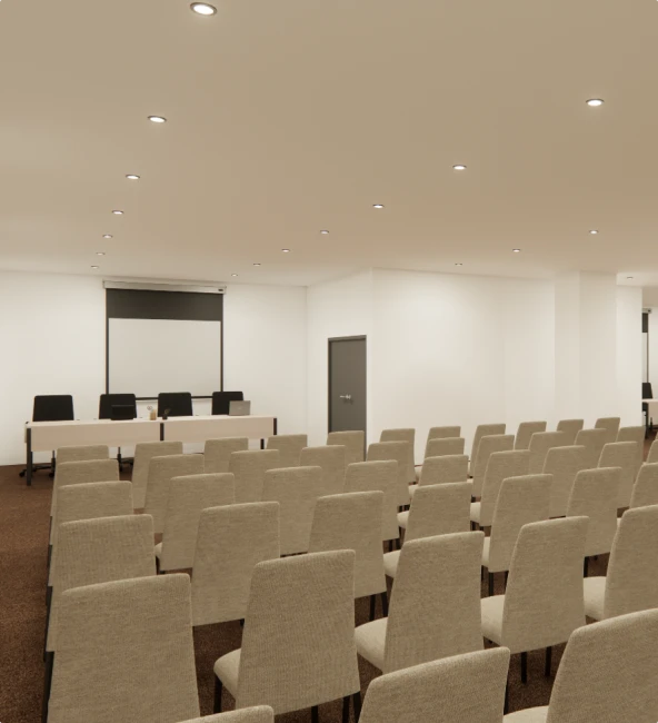 Conference room with rows of chairs and a presentation screen.