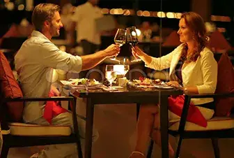 Pareja brindando en un restaurante durante una cena a la luz de las velas.