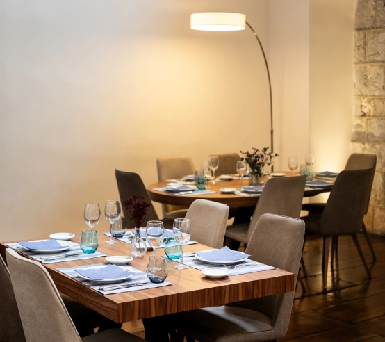 Mesa de restaurante elegante con platos y copas sobre mantel azul.
