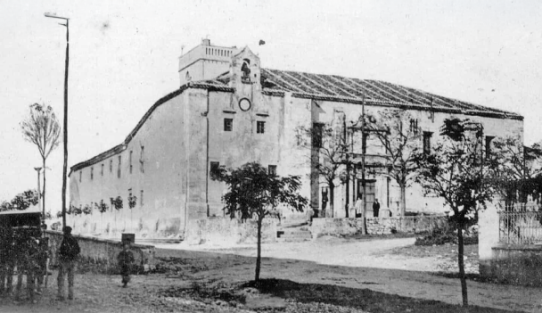 Antiguo edificio hist&oacute;rico con fachada y &aacute;rboles en blanco y negro.