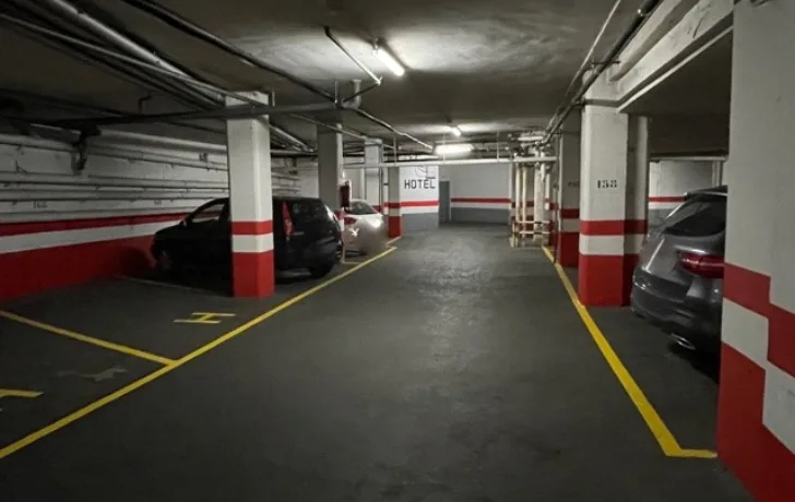 Estacionamiento subterr&aacute;neo con varios coches estacionados.