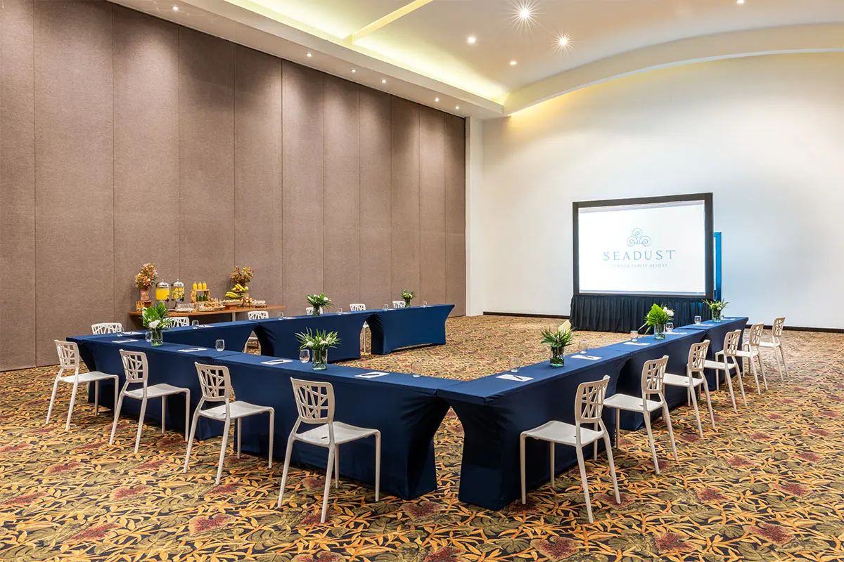 Elegant conference room with banquet tables and presentation screen.