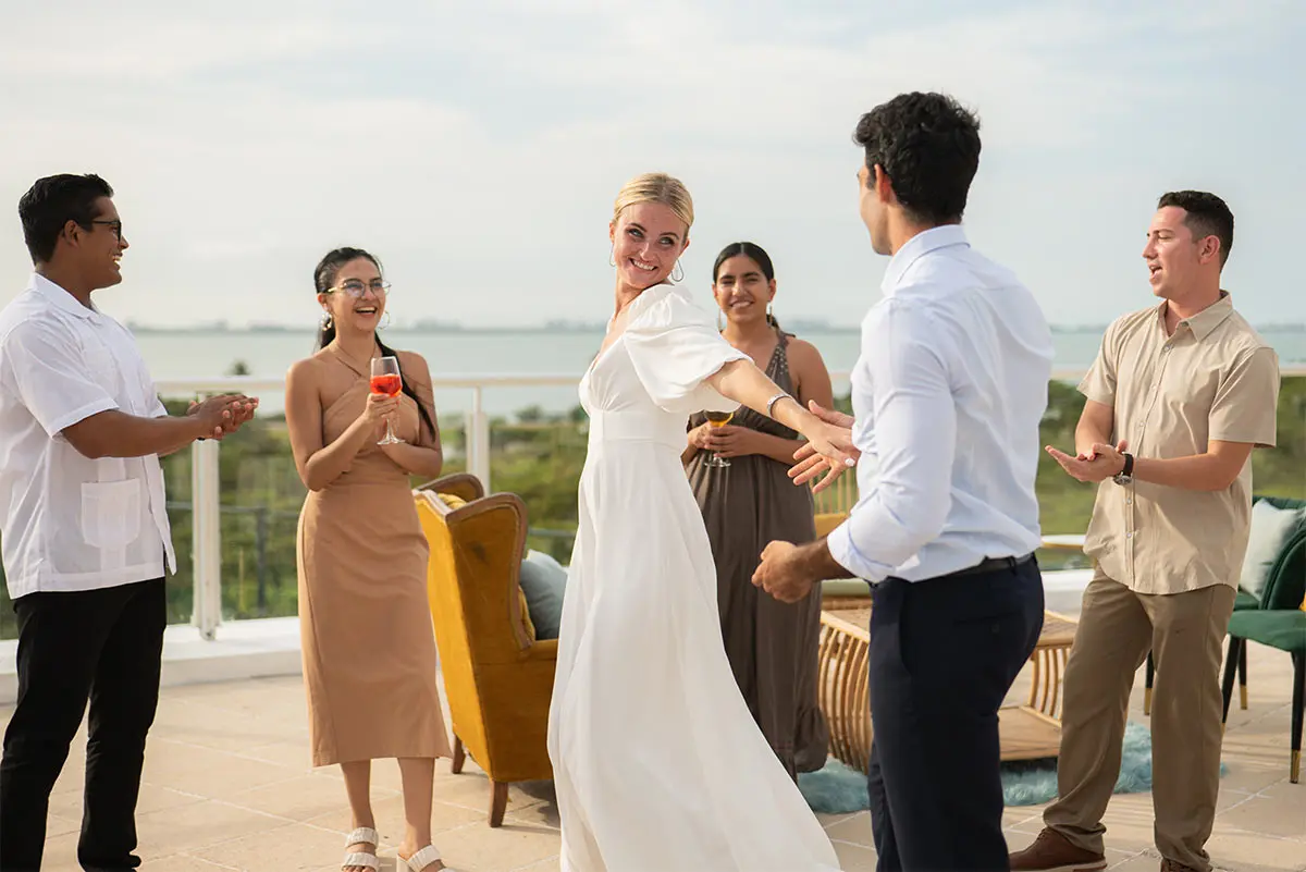 Group toasting and greeting at seaside rooftop event with cocktails and drinks