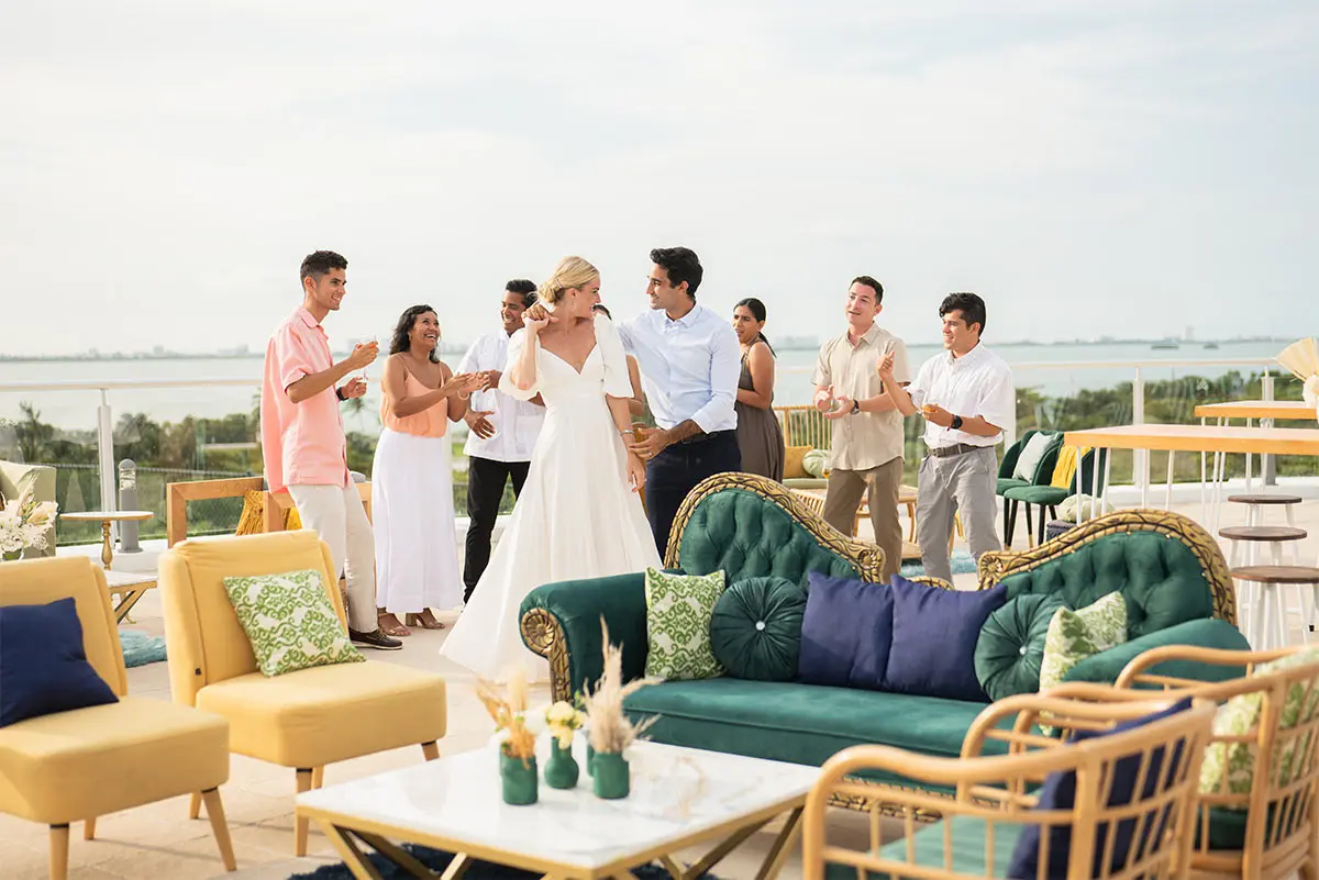 Wedding guests in white dancing on a terrace with ocean view