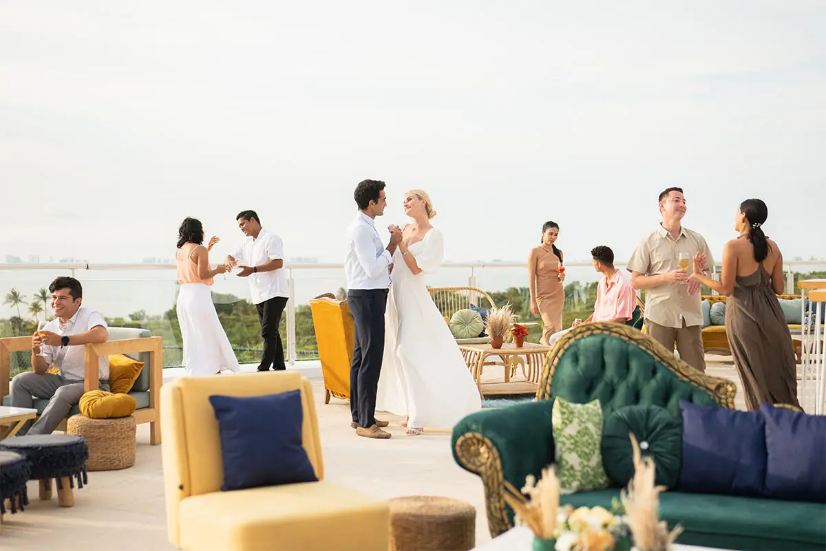 People celebrating on a rooftop patio with decorated lounge seating