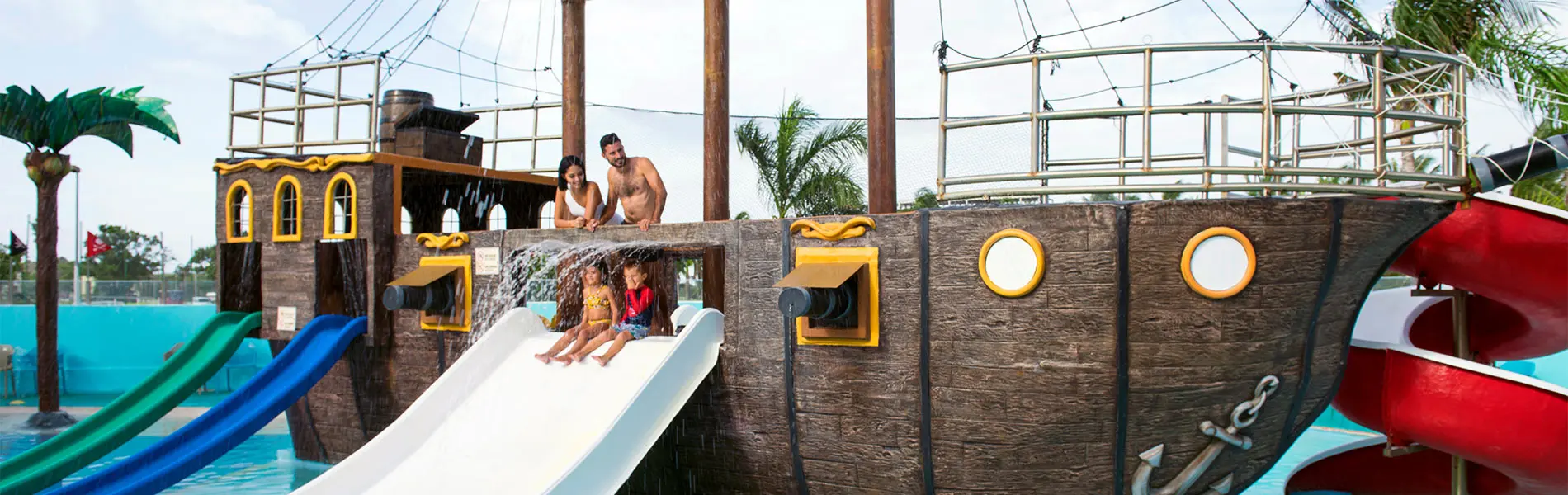 People playing on a splash pad and slide at a water park with gunite barriers