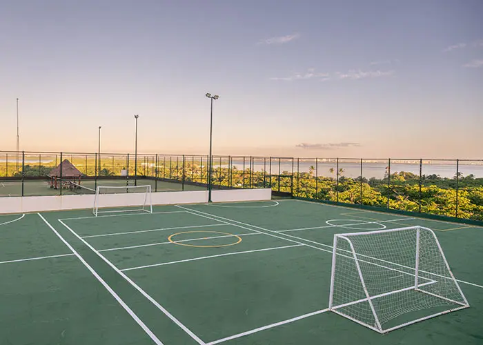 Outdoor sports court with soccer goal and ocean view at sunset