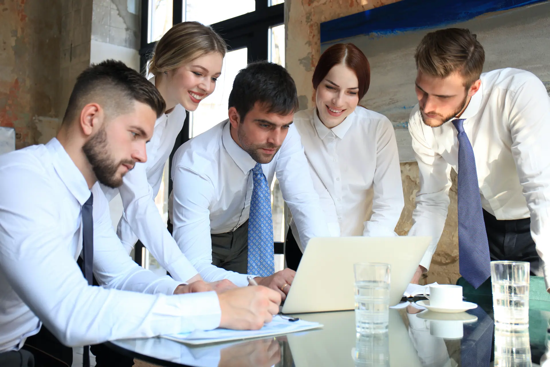 Un grupo de personas trabajando delante de una computadora port&aacute;til.