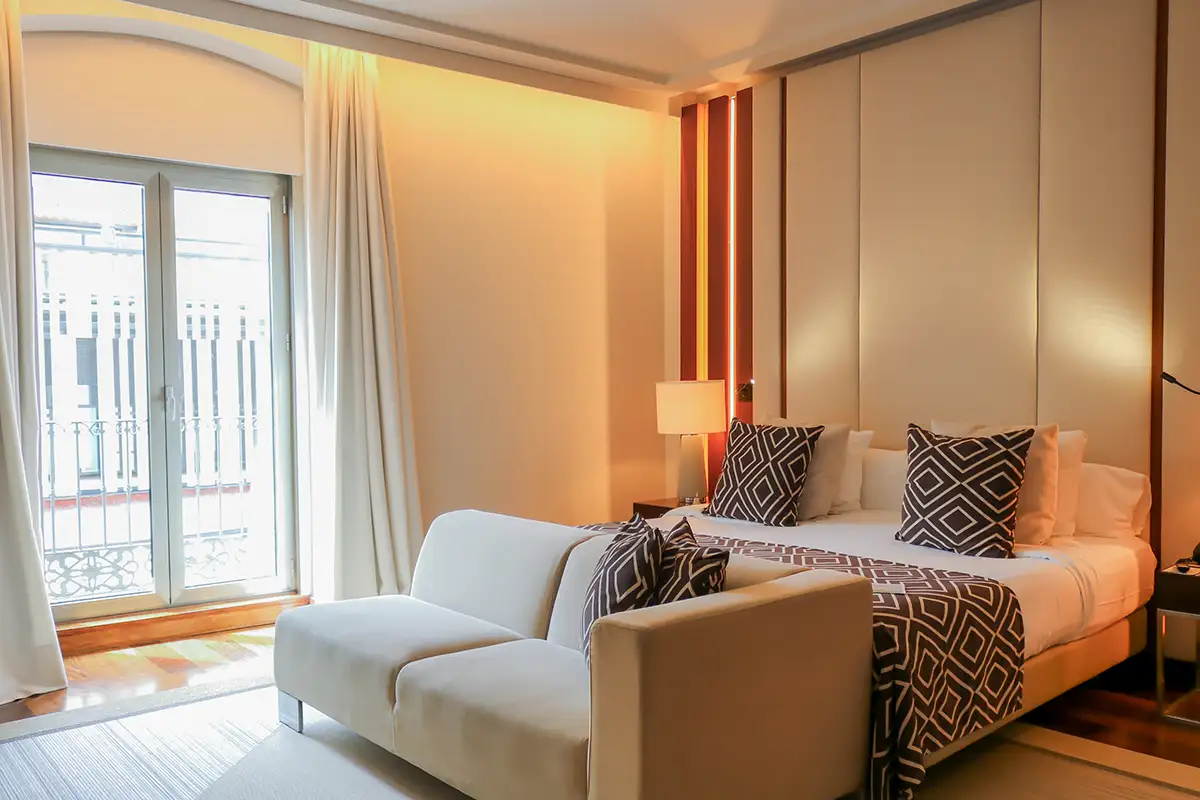 Dormitorio moderno con cama doble, almohadas y cortinas junto a la ventana