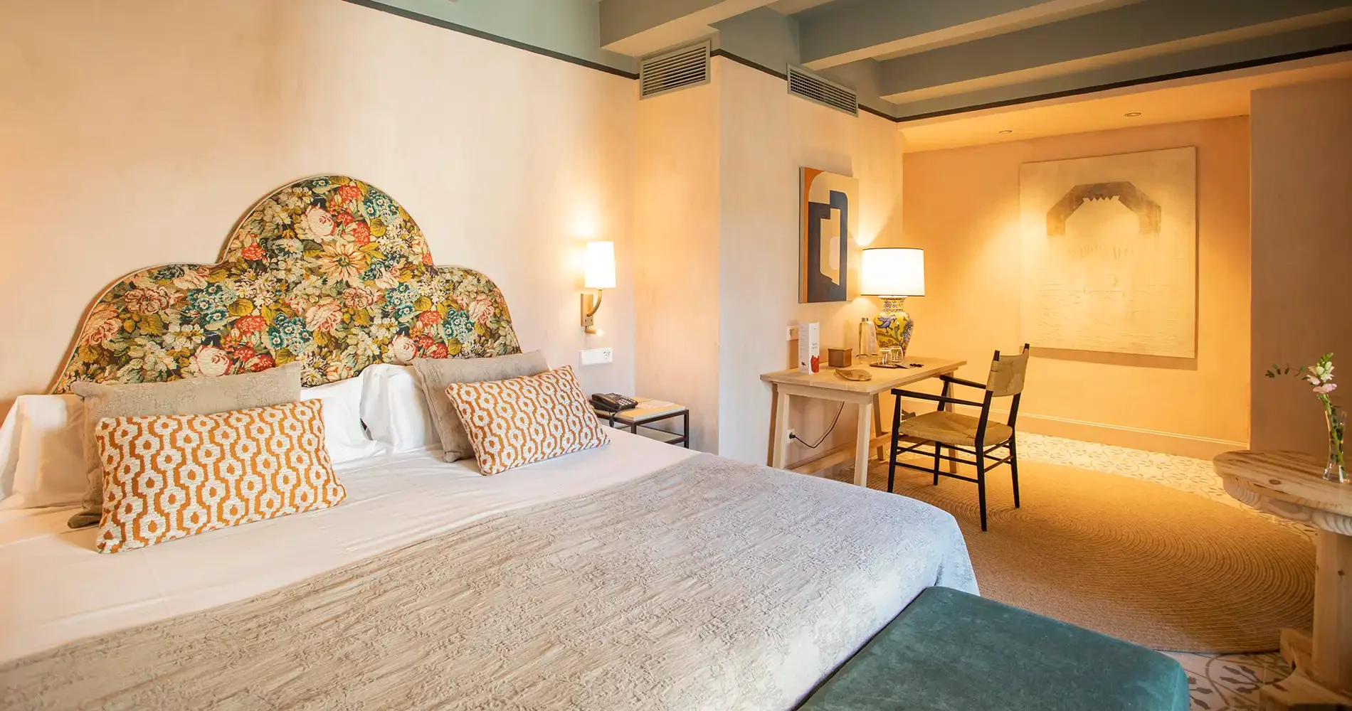 Dormitorio con cama doble, l&aacute;mparas y mesa junto a ventana luminosa