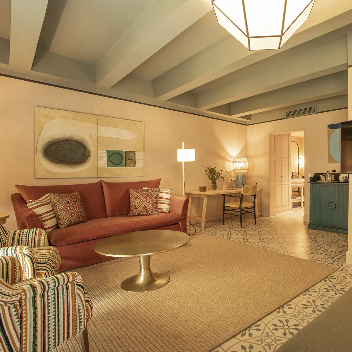 Sala de estar con sof&aacute; rojo, l&aacute;mparas y mesa de centro dorada, interior moderno