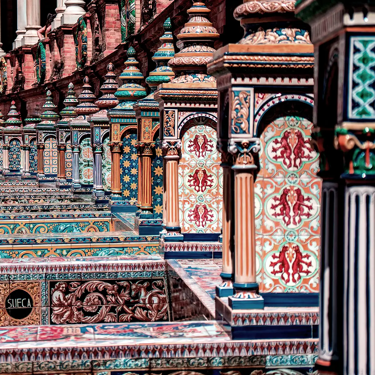 Azulejos y columnas ornamentadas en fachada de edificio hist&oacute;rico, colores verde y rojo