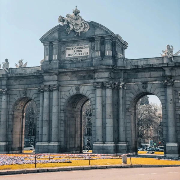Fachada de la iglesia con columnas y estatuas, arco y cielo azul.