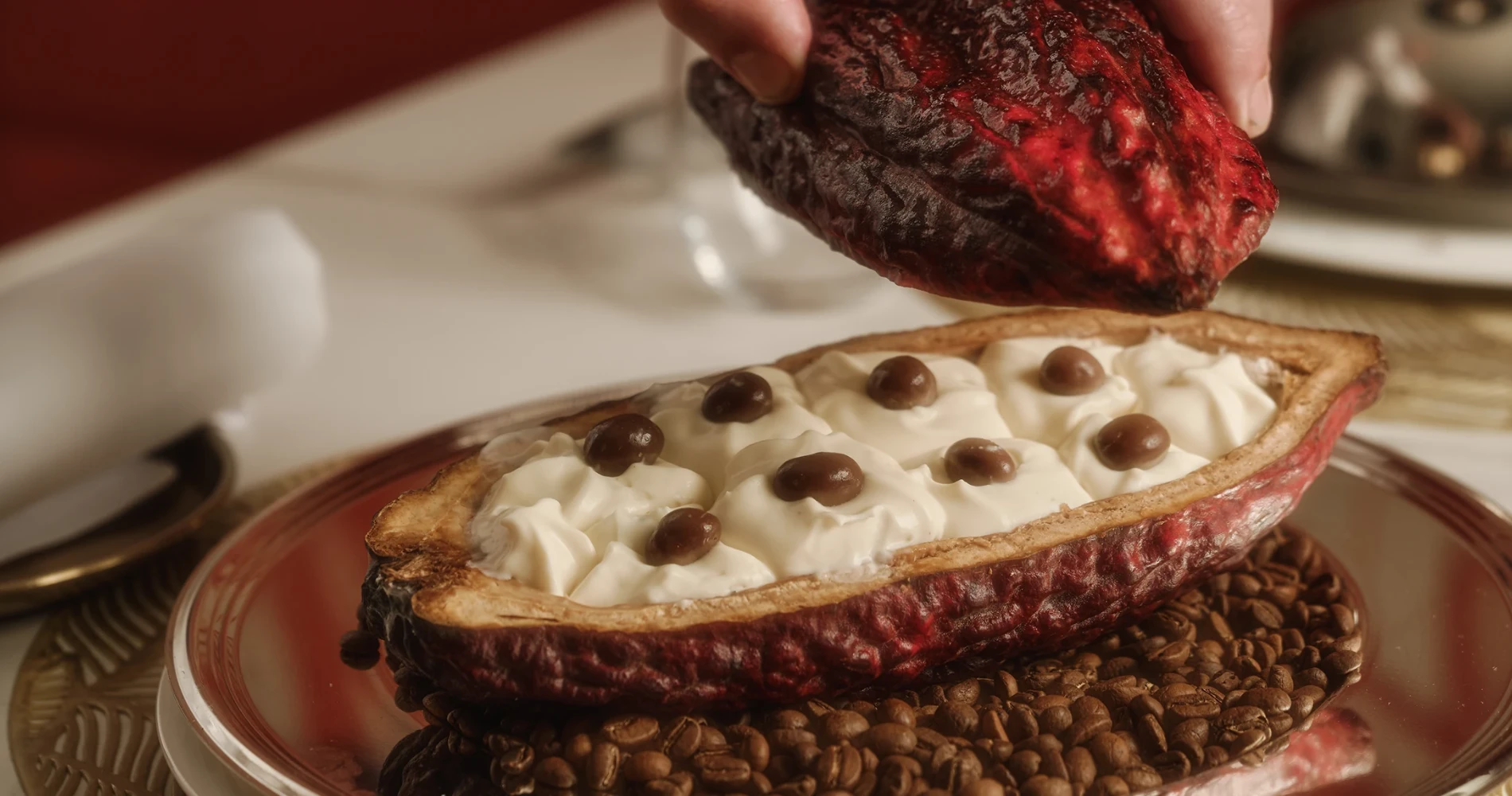 Palma partiendo chocolate negro sobre una pizza de crema blanca con chispas