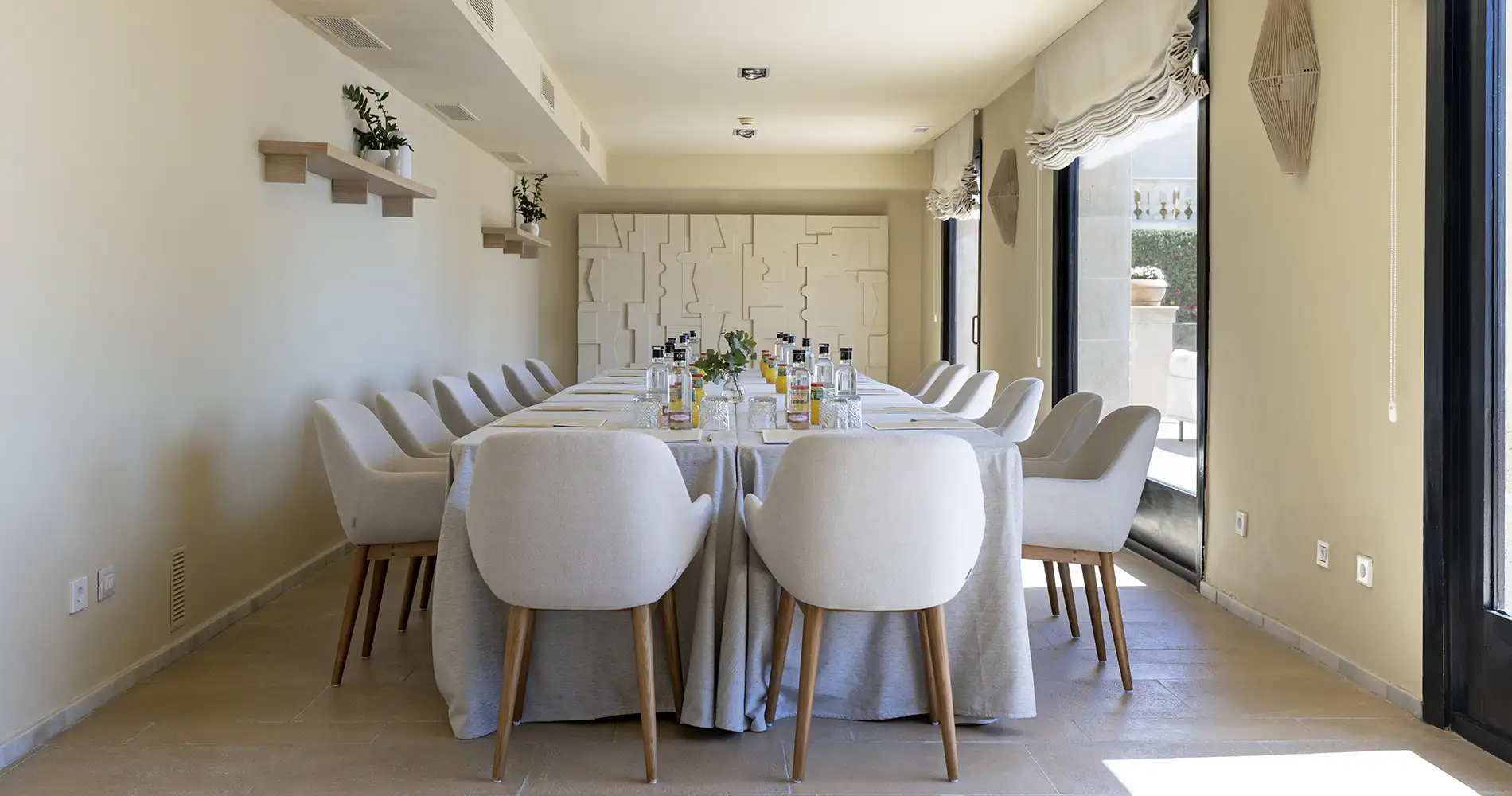 Comedor luminoso con mesa larga y sillas blancas, decoraci&oacute;n elegante