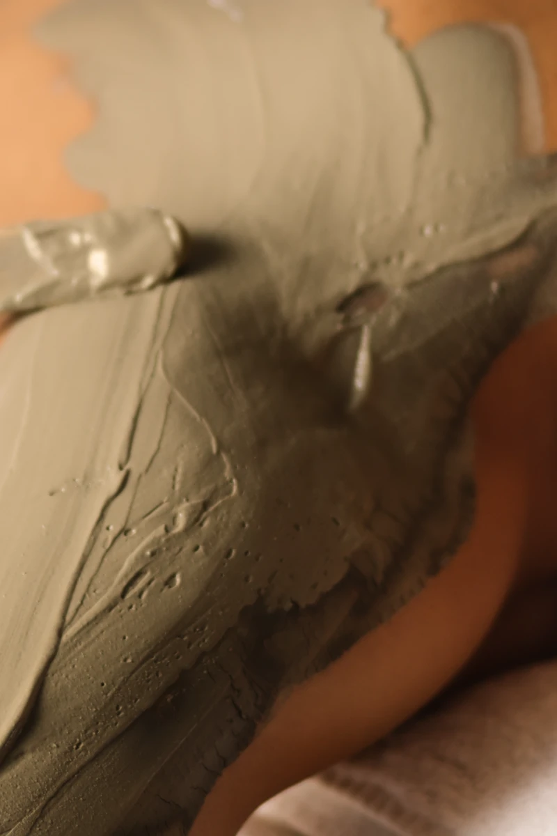 Primer plano de una campera de cuero verde con textura y costuras visibles.