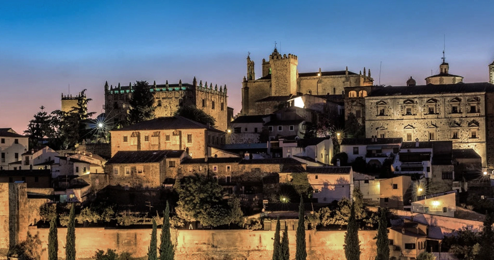 Panor&aacute;mica del casco antiguo con muralla iluminada al atardecer