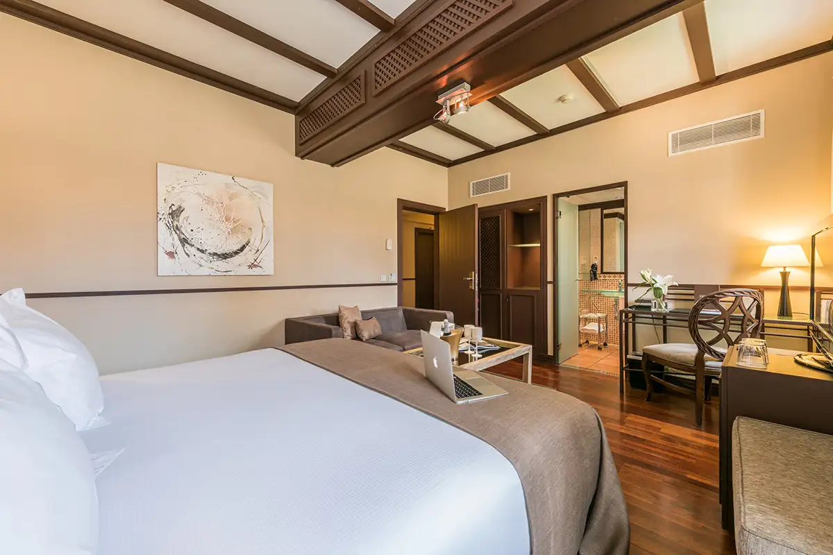 Habitaci&oacute;n de hotel con cama, cuadro, sala y salida al &aacute;rea exterior