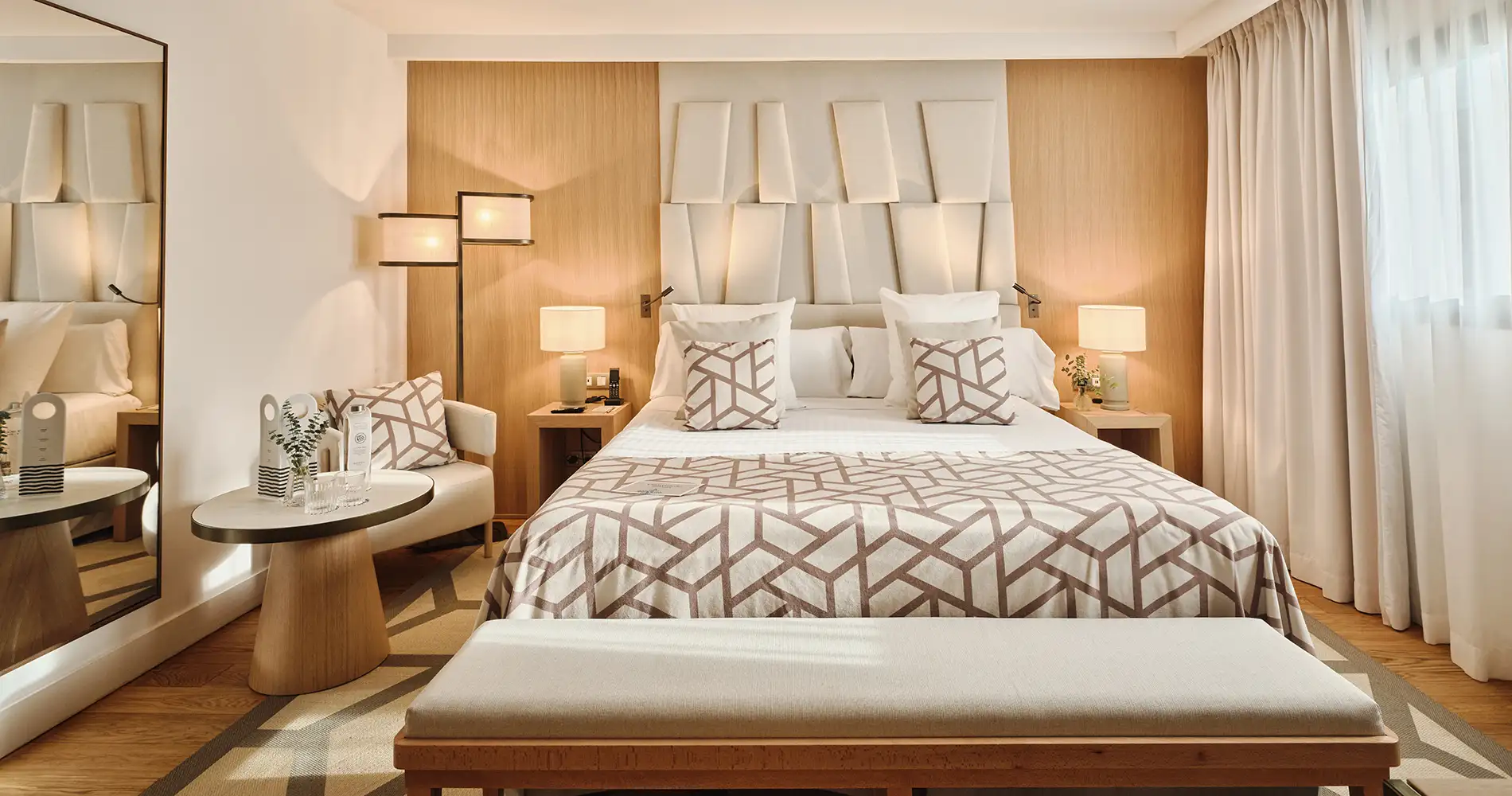 Dormitorio moderno con cama, almohadas y l&aacute;mparas en ambiente luminoso