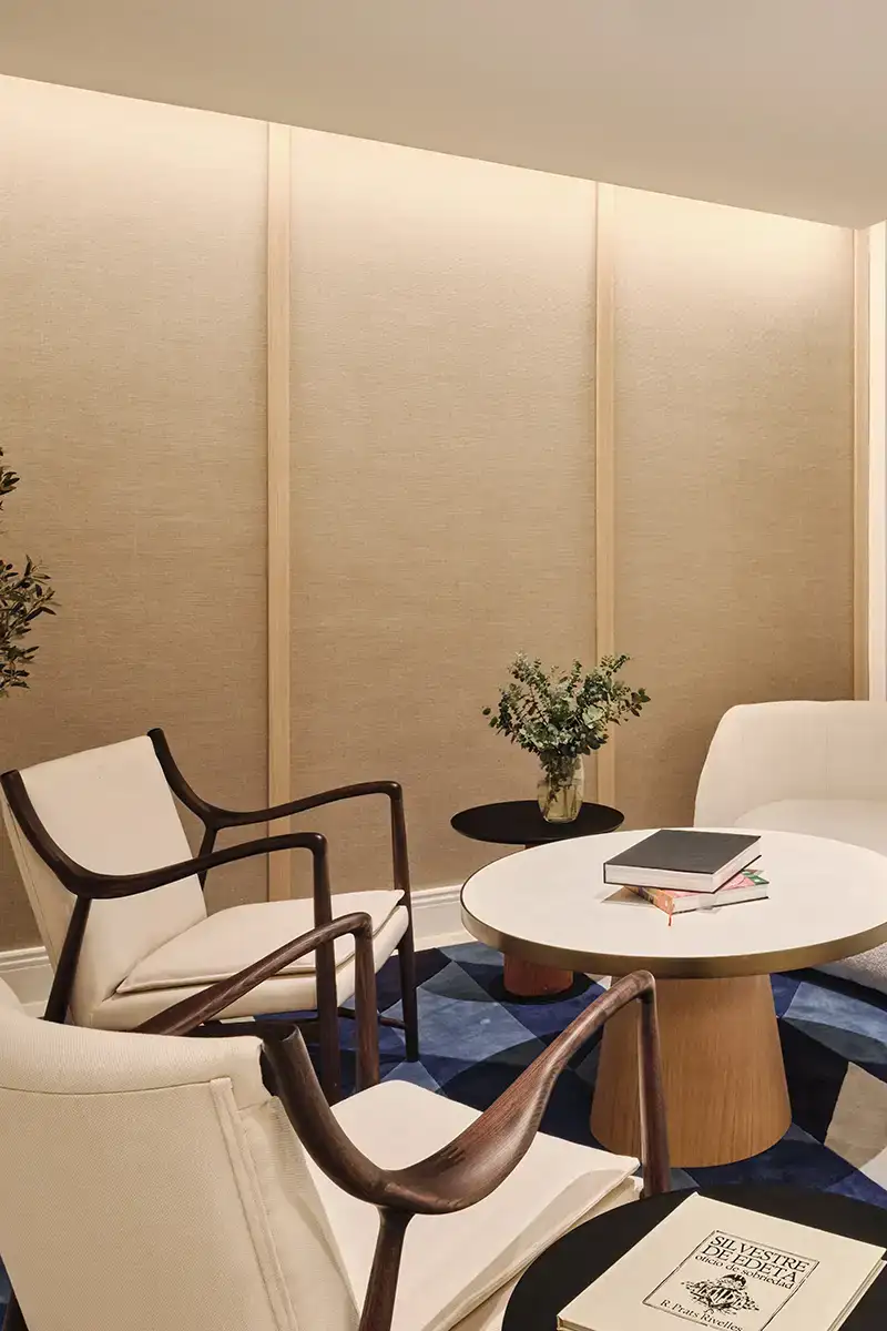 Sala de estar moderna con sillones blancos y mesa redonda beige