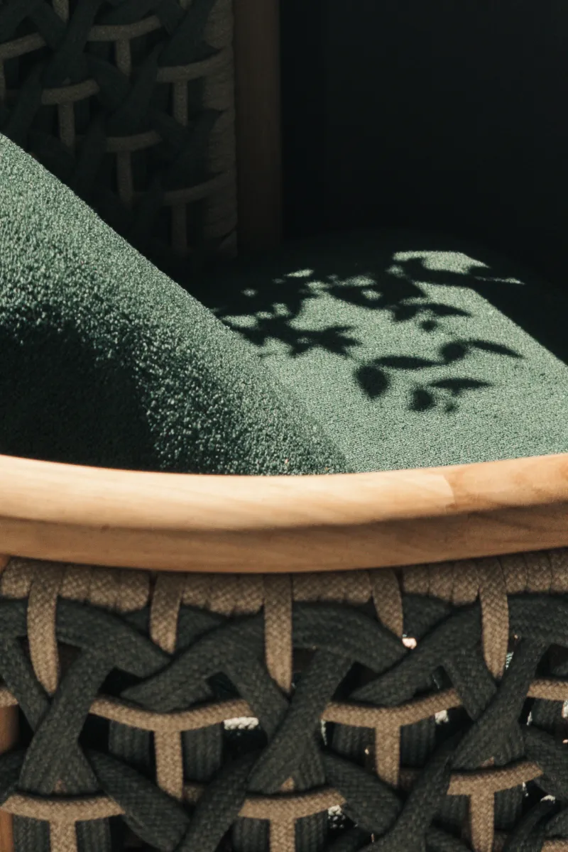 Silla con tablero de madera y patrones de sombras sobre la tela oscura