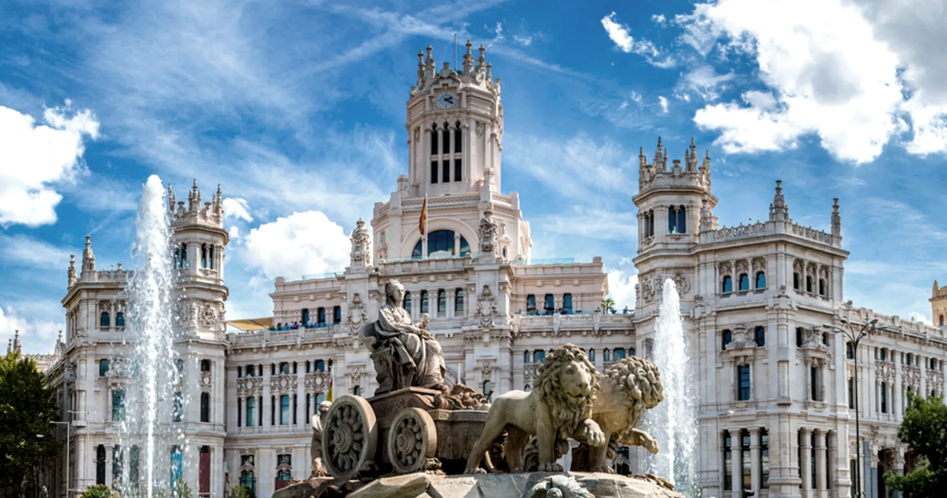 Fuente y estatua frente al Palacio de Cibeles, Madrid, con cielo azul