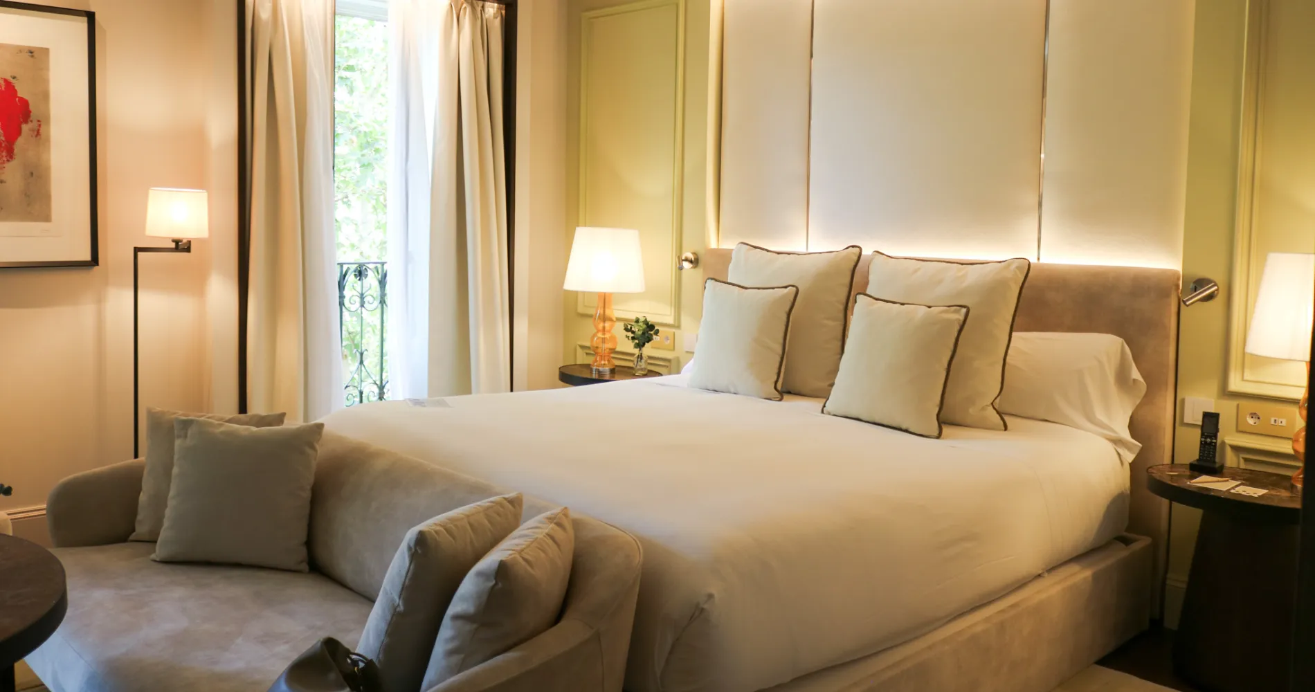 Dormitorio elegante con cama doble, l&aacute;mparas y cortinas beige