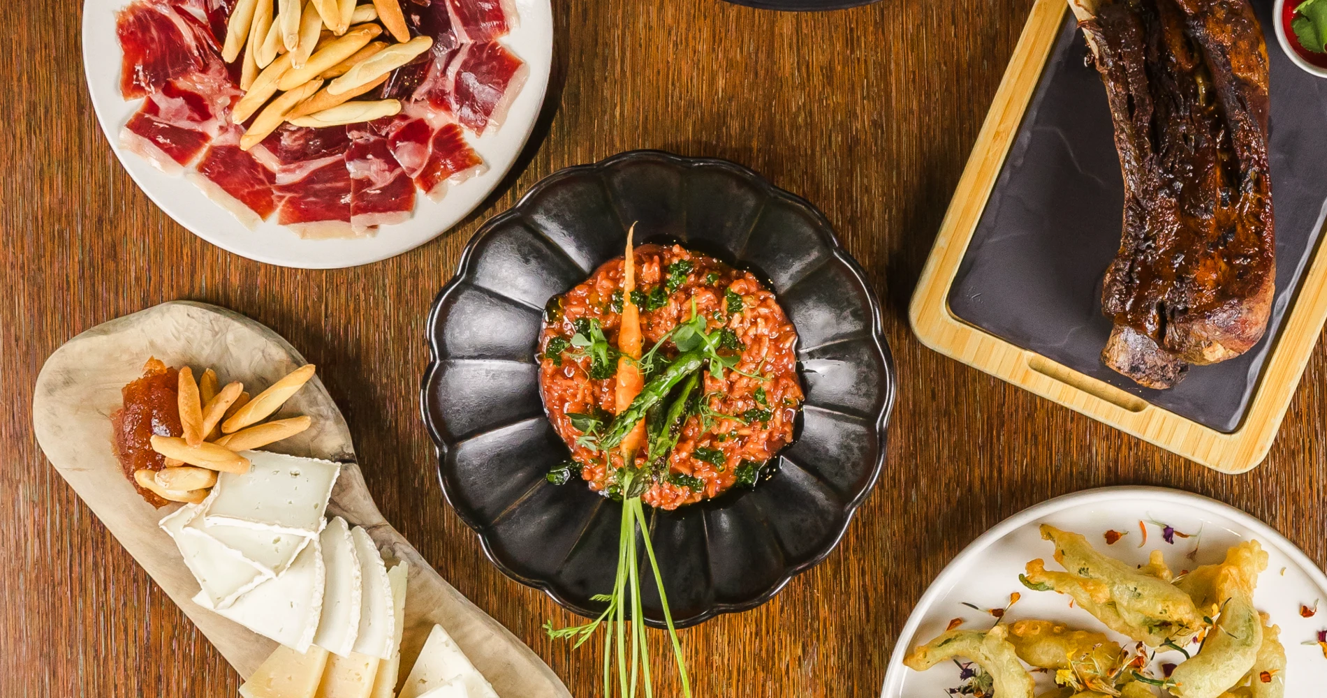 Plato con salsa roja, jam&oacute;n serrano, queso, verduras y una costilla a la parrilla