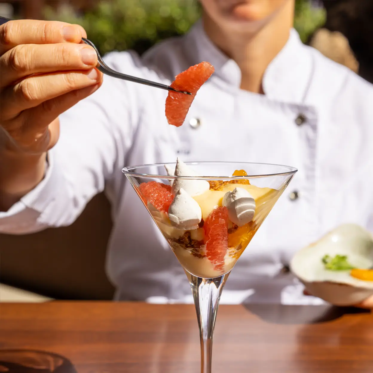 A delicious fruit parfait dessert with grapefruit and cream served in a glass.