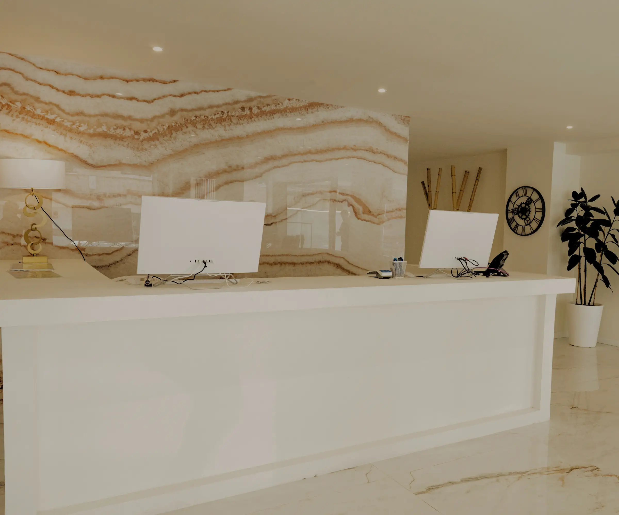 Recepci&oacute;n moderna con decoraci&oacute;n minimalista y fondo de m&aacute;rmol.