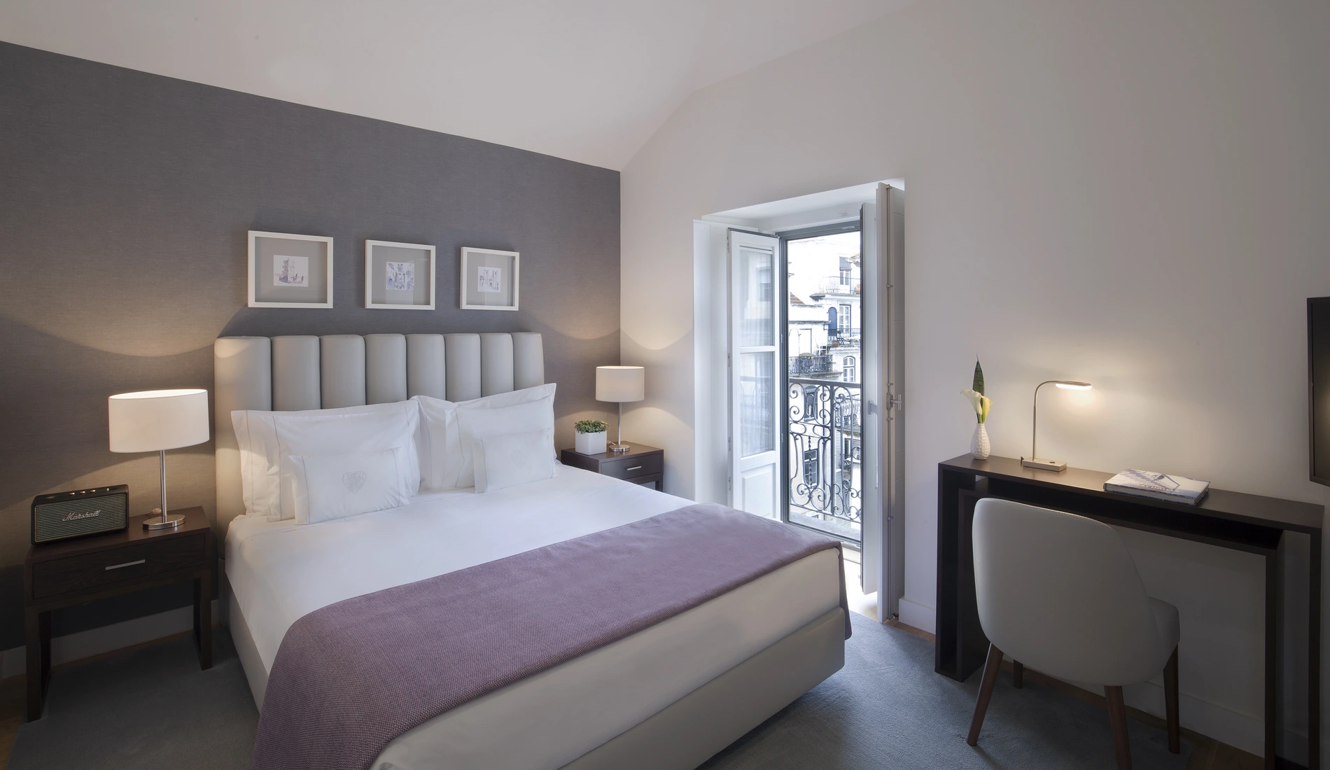 Quarto elegante com cama ampla e varanda iluminada.