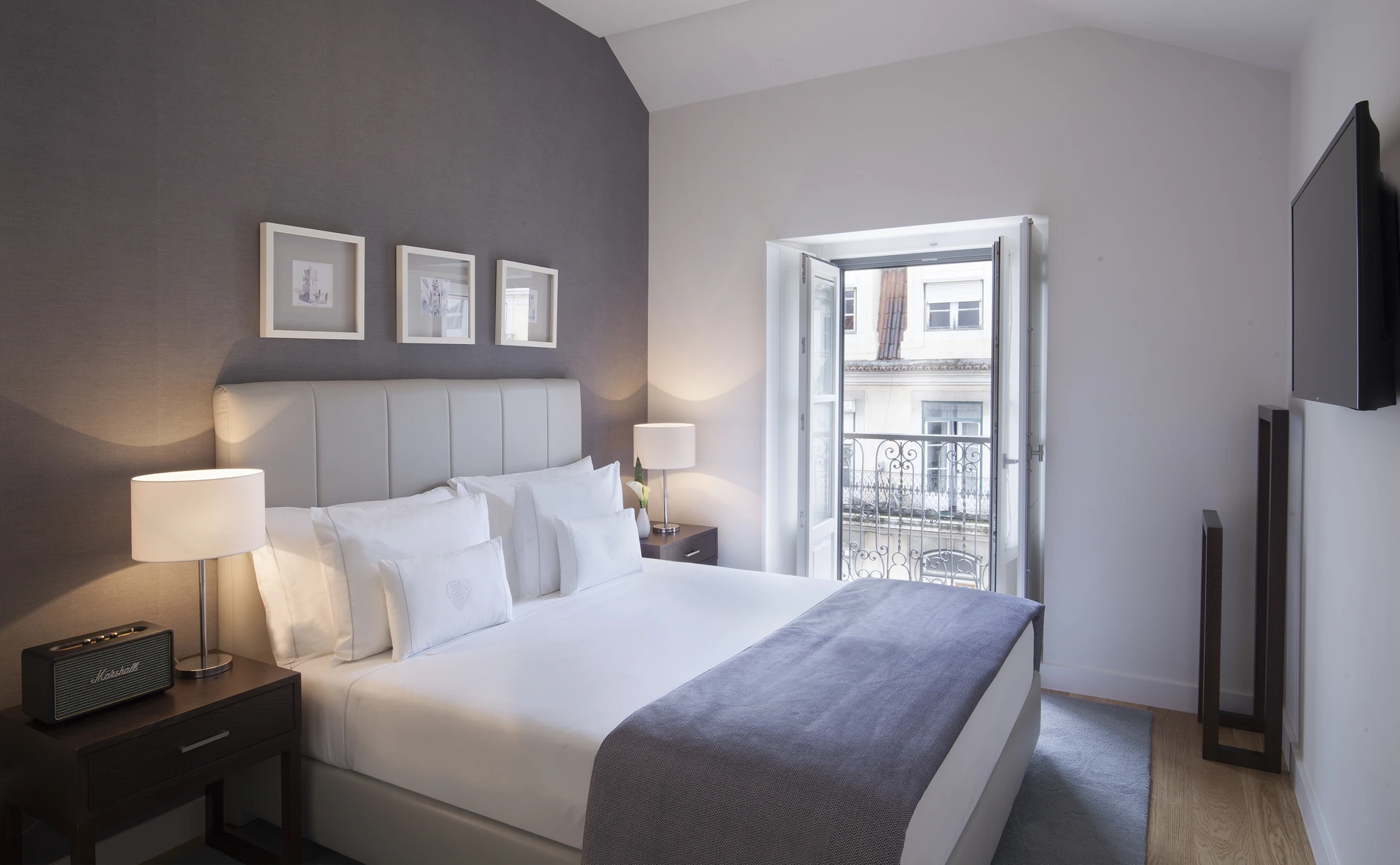 Quarto moderno com cama de casal e varanda iluminada.