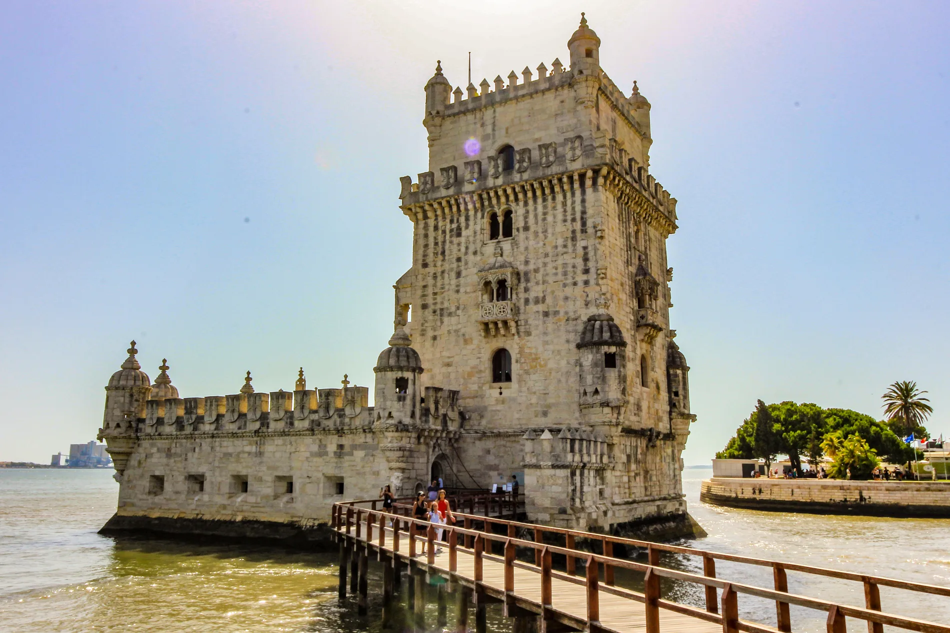 Torre hist&oacute;rica com ponte sobre a &aacute;gua em dia ensolarado.