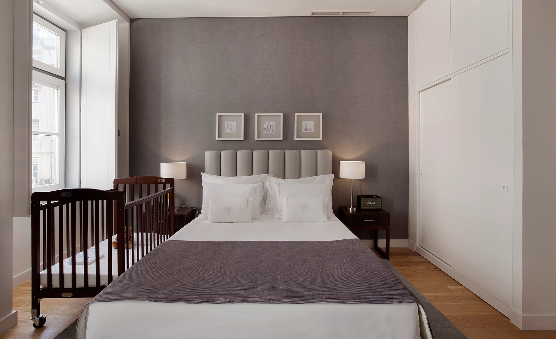 Quarto acolhedor com cama de casal e ber&ccedil;o ao lado.