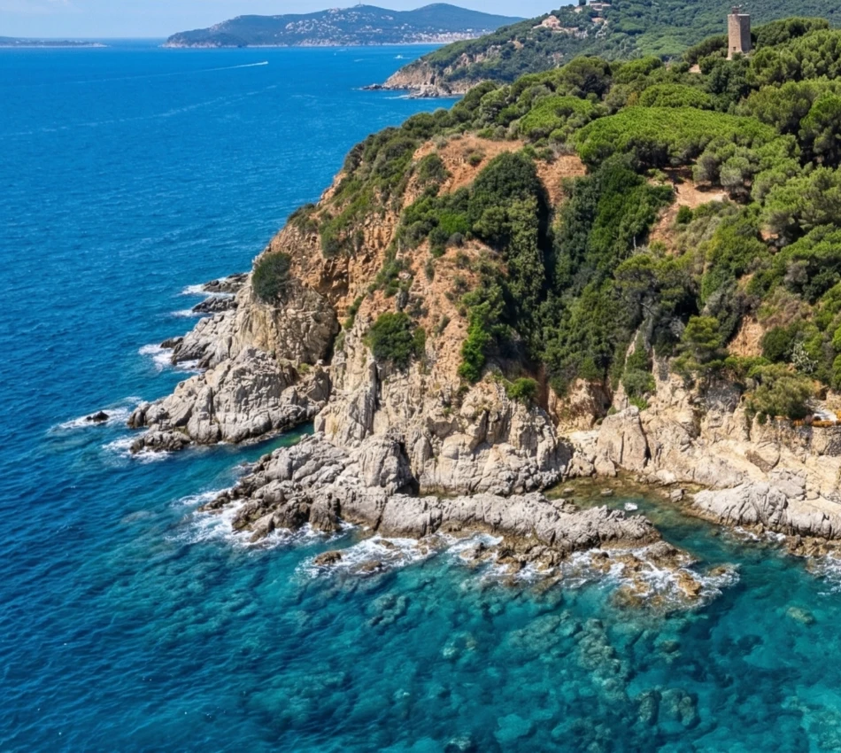 Costa rocosa con acantilados verdes y agua turquesa bajo un cielo azul.
