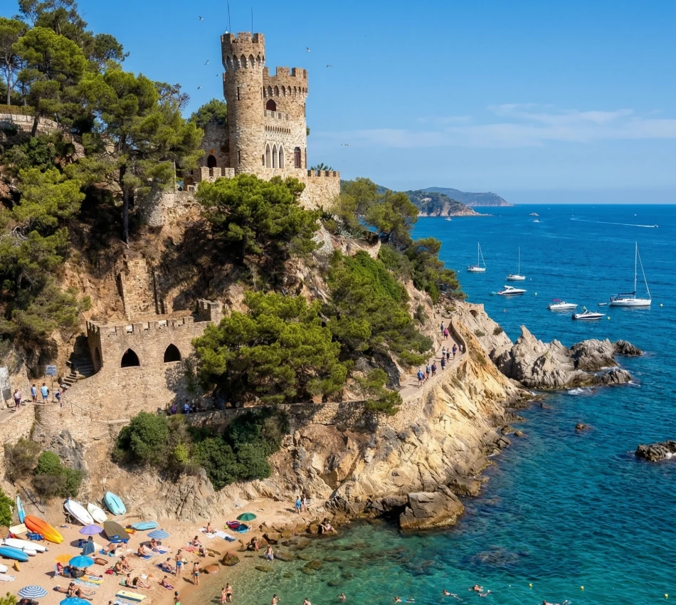 Castillo junto a un acantilado con vista al mar, rodeado de pinos, playa y barcos.