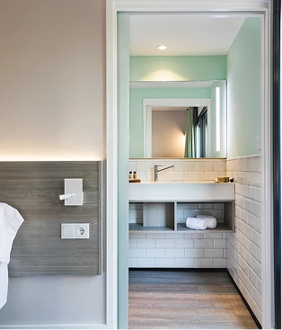 Pasillo moderno con lavabo y pared verde claro, vista interior.