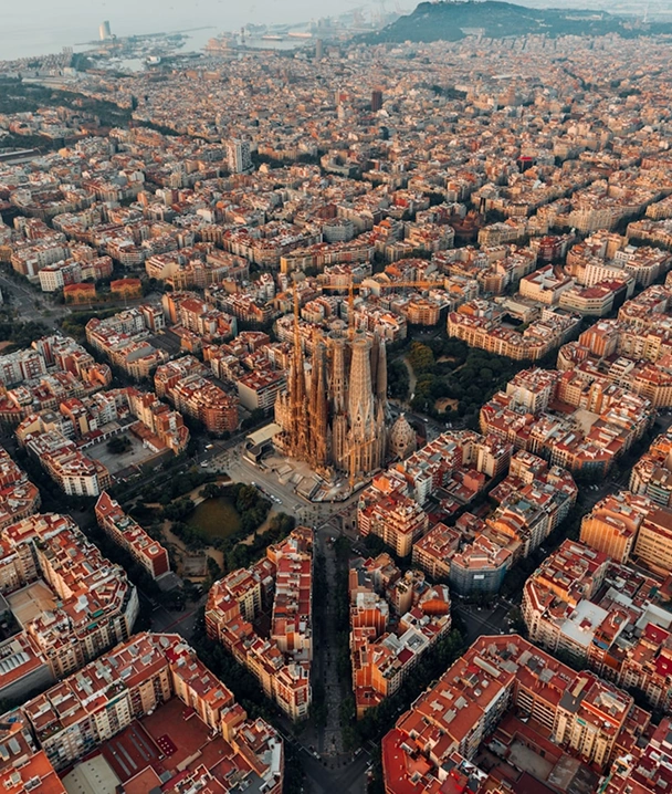 Vista a&eacute;rea de una ciudad densa con edificios y la Sagrada Fam&iacute;lia al centro.