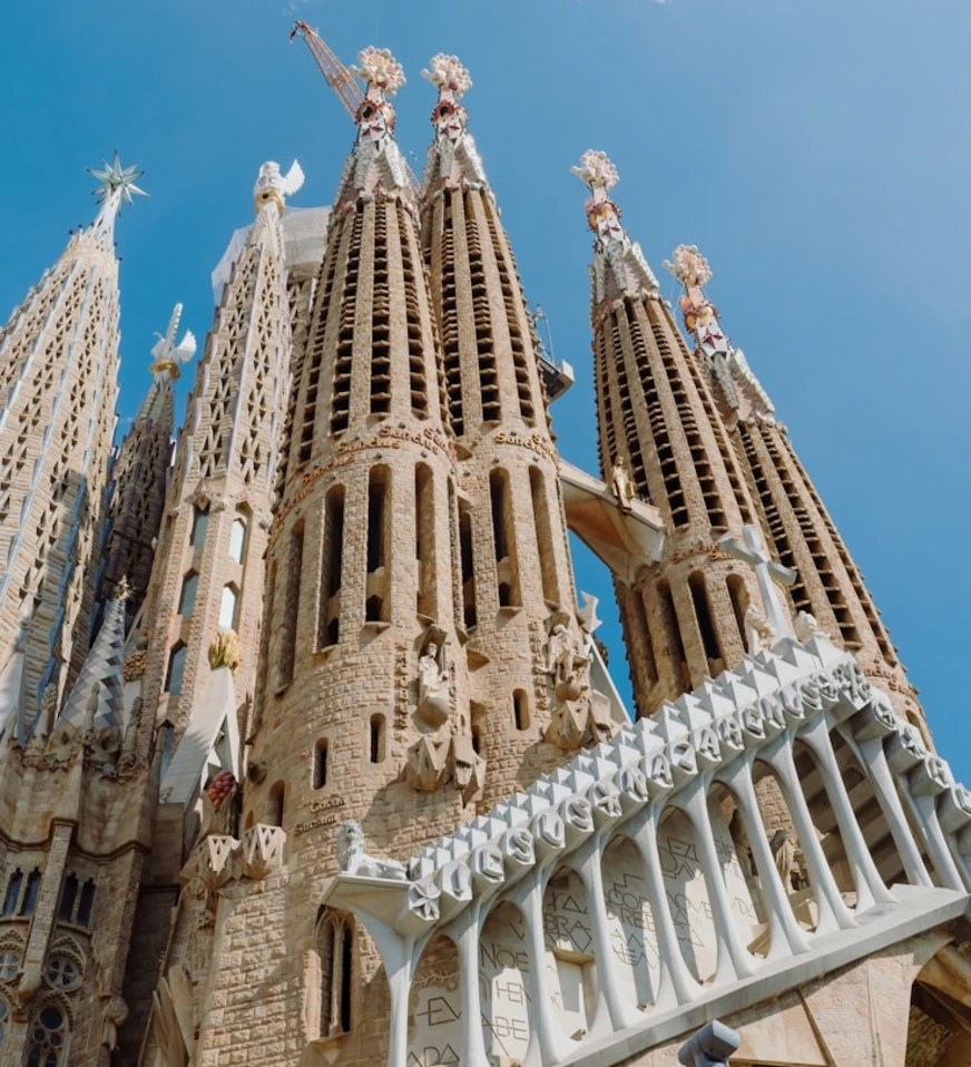 Sagrada Familia, fachada con torres y pin&aacute;culos sobre cielo azul