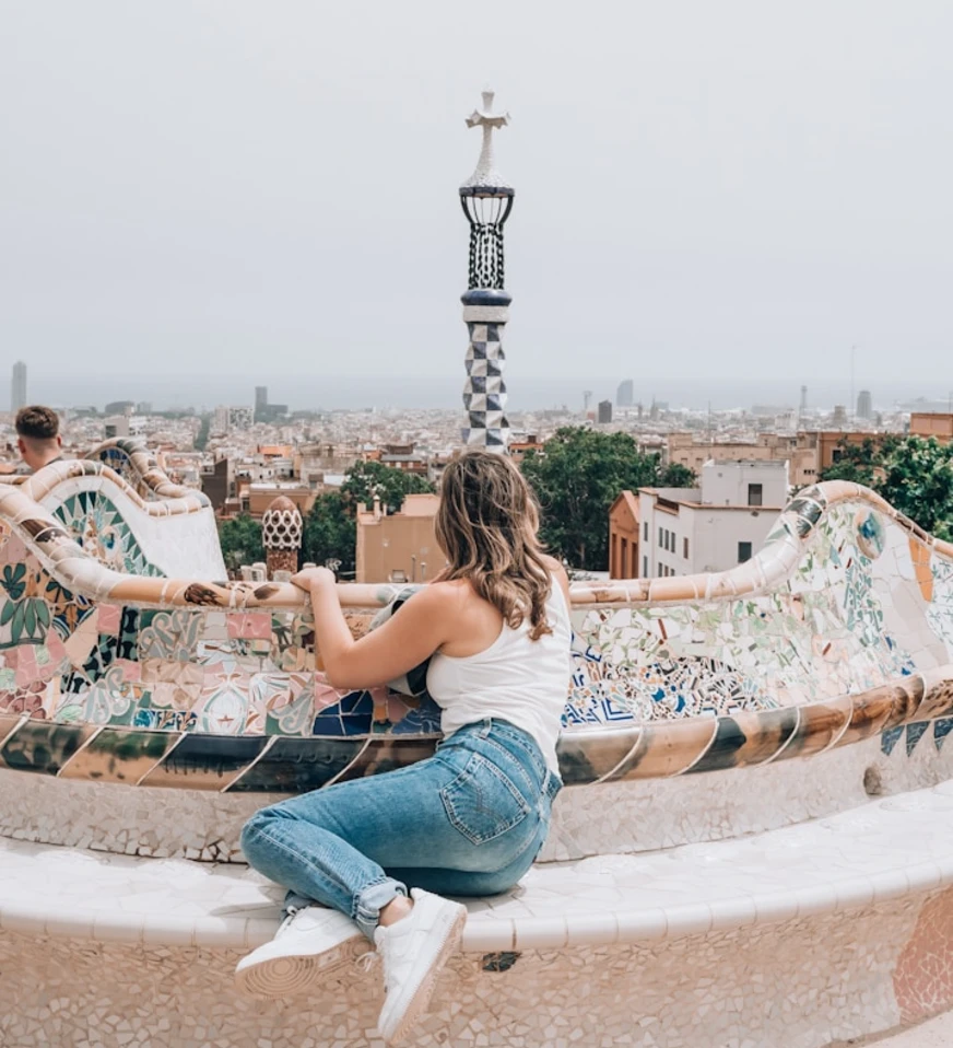 Mujer con brazos abiertos en azotea con mosaicos y torre de cer&aacute;mica al fondo