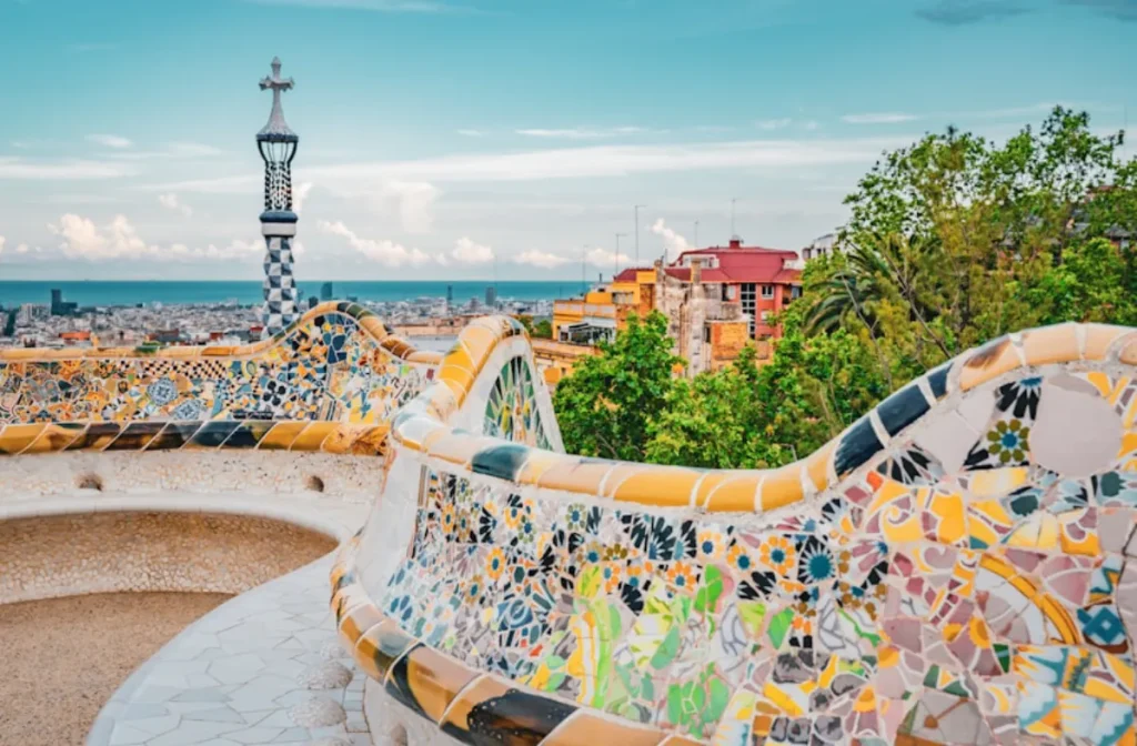 Parque G&uuml;ell: serpentina con mosaicos y torre del reloj frente al mar