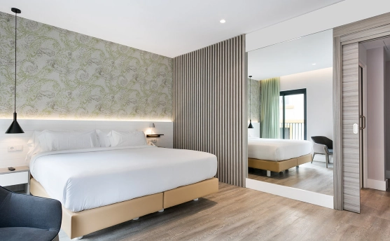Dormitorio moderno con cama, pared verde y detalles en madera.