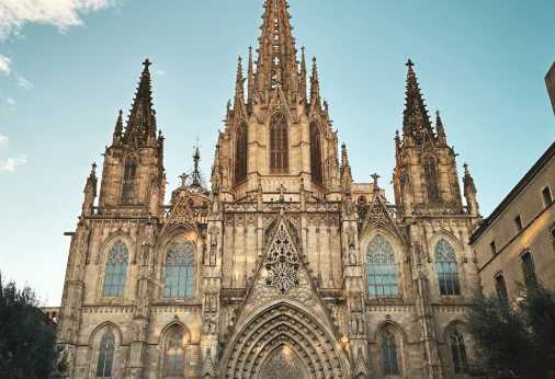 Catedral g&oacute;tica con torres y fachada ornamentada bajo cielo azul.